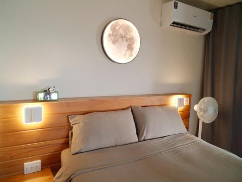 a bedroom with a bed with a clock on the wall at Tantawan sea view residence 山海居 in Salad Beach