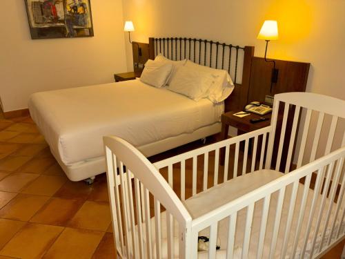a small bedroom with a bed and a crib at Sercotel Toledo Renacimiento in Toledo