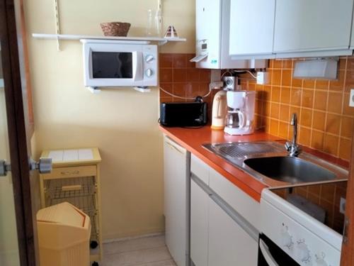 une petite cuisine avec un évier et un micro-ondes dans l'établissement Studio agréable en centre ville, 6ème étage - FR-1-331-45, à Les Sables-dʼOlonne