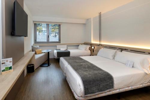 アンドラ・ラ・ベリャにあるSercotel Delfos Andorraの大型ベッド1台、テレビが備わる客室です。
