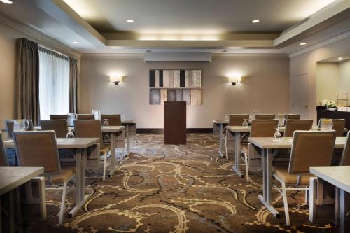 a dining room with tables and chairs and a podium at Courtyard Worcester in Worcester