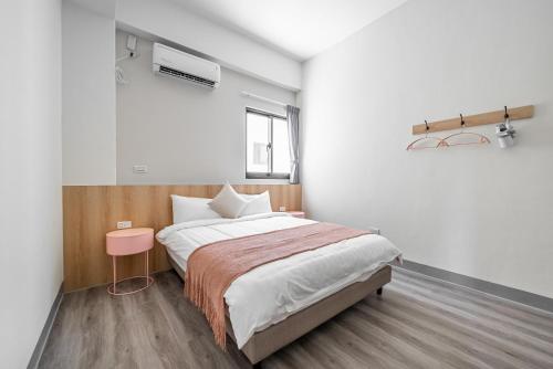 a bedroom with a large bed and a pink table at Penghu Lemongrass in Magong