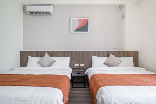 two beds in a hotel room with two beds sidx sidx sidx at Penghu Lemongrass in Magong