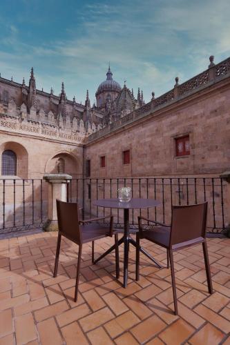 a patio with a table and chairs in front of a building at Sercotel Puerta de la Catedral in Salamanca