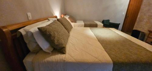 two beds in a hotel room with two beds at Pousada Alpes Azul in Campos do Jordão