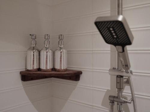 four glass bottles on a shelf in a bathroom at Tantawan sea view residence 山海居 in Salad Beach