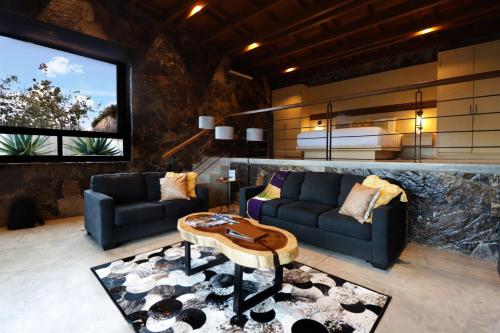 a living room with two couches and a table at Parra del Valle Hotel Boutique in Valle de Guadalupe