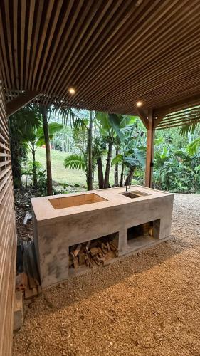 a concrete table with a sink under a roof at Camping do Bosque - Deck 01 in Rodeio
