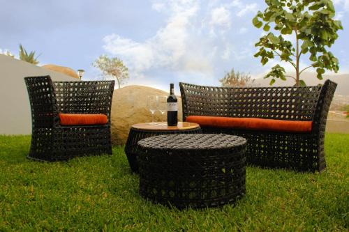 two chairs and a table with a bottle of wine at Parra del Valle Hotel Boutique in Valle de Guadalupe