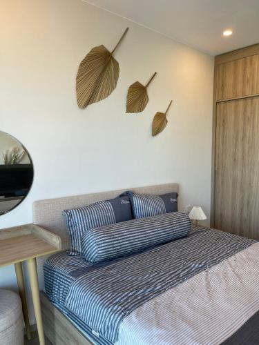 a bedroom with a bed and two umbrellas on the wall at The Sóng Vũng Tàu Escape Apartment in Vung Tau