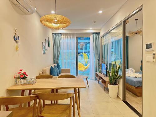 a dining room and living room with a table and chairs at The Sóng Vũng Tàu Escape Apartment in Vung Tau