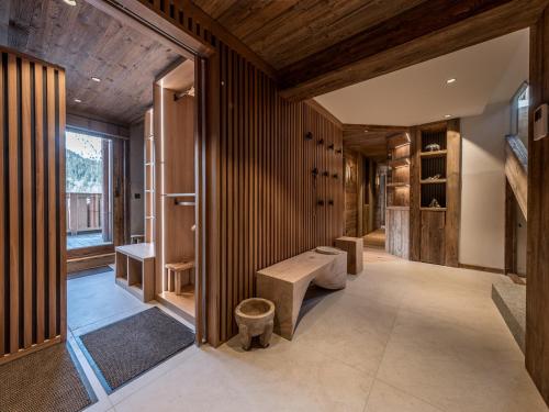 La salle de bains est pourvue de murs lambrissés et d'un banc. dans l'établissement Penthouse de luxe avec terrasse, sauna et bain nordique, 5 chambres - FR-1-613-123, à Les Allues