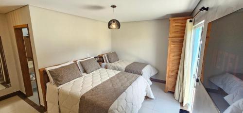 a small bedroom with two beds and a window at Pousada Alpes Azul in Campos do Jordão