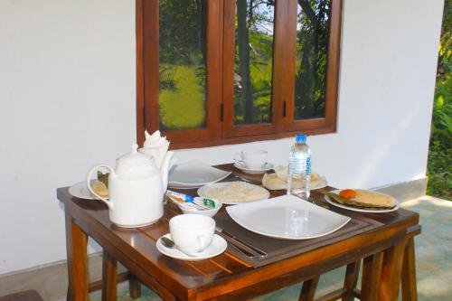 a table with plates of food and a window at Ehalagala Lake and Paddy view Lodge in Sigiriya