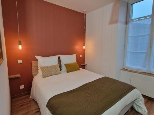 a bedroom with a large bed with two pillows at Studio calme centre-ville Châteauroux avec parking - FR-1-591-725 in Châteauroux