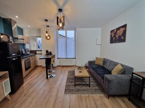 un salon avec un canapé et une table dans l'établissement Studio moderne et calme au centre-ville avec parking sécurisé - FR-1-591-723, à Châteauroux