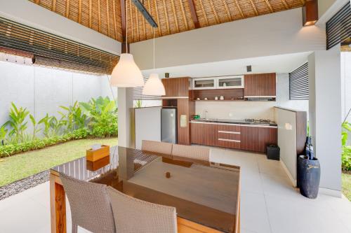 an open kitchen with a table and chairs in it at Villa Jerami & Spa in Seminyak