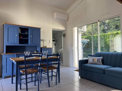 une cuisine avec des armoires bleues et une table et des chaises dans l'établissement Vaux-sur-Mer: Villa 2 chambres pour 5 pers, 450m Plage, Parking, Clim - FR-1-738-47, à Vaux-sur-Mer