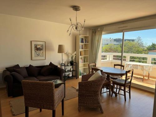 un salon avec un canapé, une table et des chaises dans l'établissement Royan : Appartement 47m², Balcon, Parking privé, Ascenseur - FR-1-738-48, à Royan
