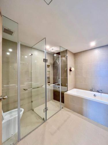 a bathroom with a glass shower and a tub and a sink at The Sóng Vũng Tàu Escape Apartment in Vung Tau