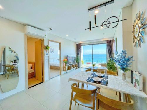 a dining room and living room with a table and chairs at The Sóng Vũng Tàu Escape Apartment in Vung Tau