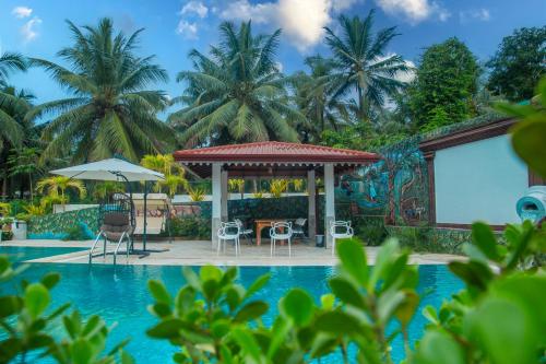 a swimming pool with a gazebo next to a resort at Imbulana Villa & Tea Estate in Ruwanwella
