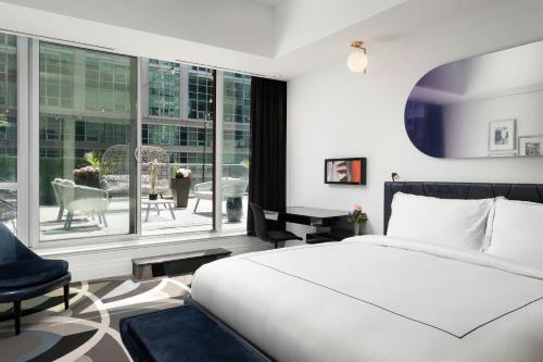 a bedroom with a bed and a large window at BISHA, a Luxury Collection Hotel, Toronto in Toronto