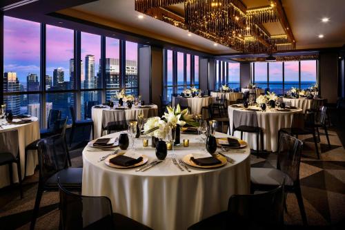 a banquet room with tables and chairs and windows at BISHA, a Luxury Collection Hotel, Toronto in Toronto