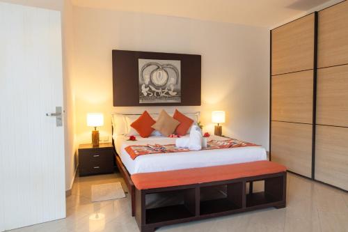 a bedroom with a large bed with orange pillows at Praslin Paradise in Baie Sainte Anne