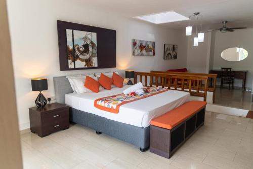 a bedroom with a large bed with orange pillows at Praslin Paradise in Baie Sainte Anne