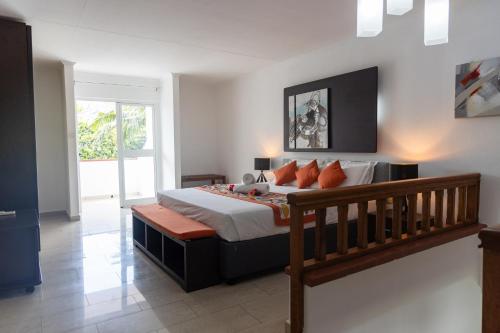 a bedroom with a large bed with a wooden bench at Praslin Paradise in Baie Sainte Anne