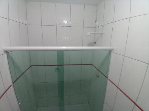 a glass shower in a white tiled bathroom at Casa para temporada até 9 pessoas, próximo Cabo Frio e São Pedro da Aldeia in São Pedro da Aldeia