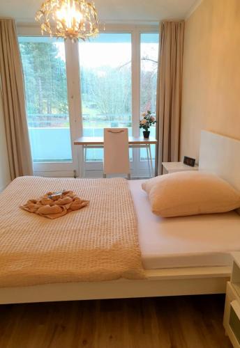 ein Schlafzimmer mit einem großen Bett und einem Kronleuchter in der Unterkunft BonnJour - 7 Lounge Apartment in Bonn