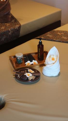 a table with a plate of food and a towel at BeSS Mansion Hotel Surabaya in Wonocolo