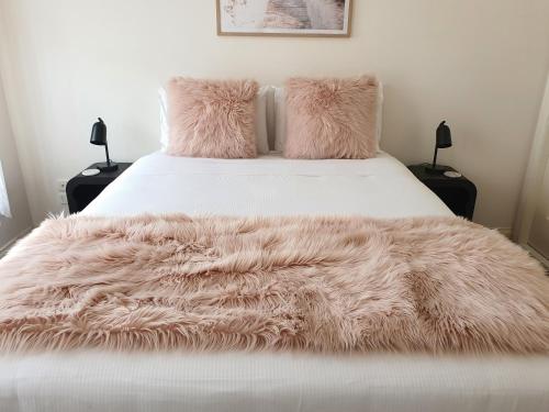 a bed with a faux fur blanket on it at Cosy and Peaceful Retreat in Melbourne