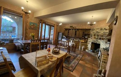 Una sala de estar con una mesa y una chimenea. en Monument Guesthouse, en Ereván