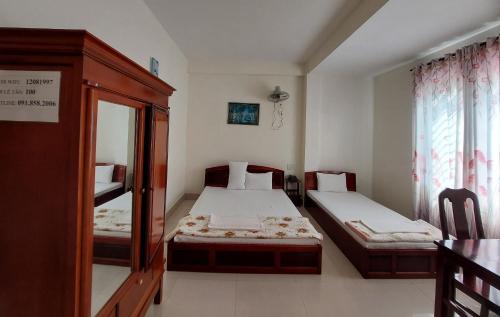a small room with two beds and a mirror at Thinh Khang Hotel Vung Tau in Vung Tau