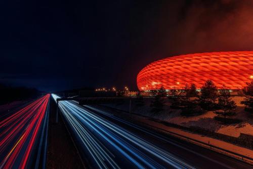 a building with a red roof at night at Holiday Inn - the niu, Loco Munich North by IHG in Munich