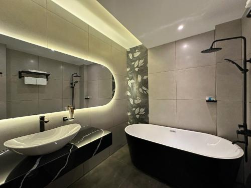 a bathroom with a sink and a bath tub at LION 16 Hotel in Can Tho