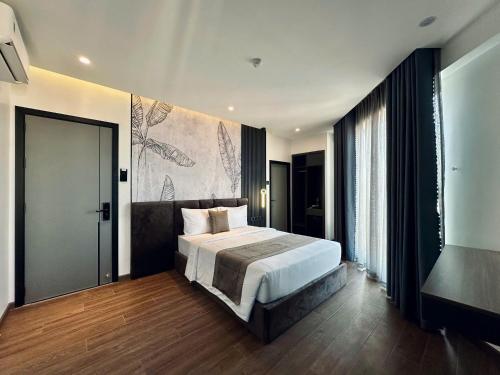 a bedroom with a bed and a painting on the wall at LION 16 Hotel in Can Tho