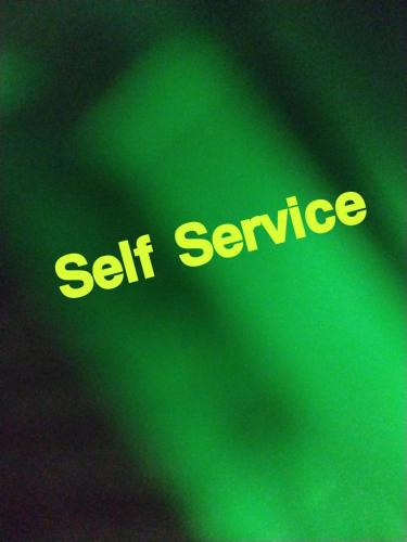 a green sign with the words self service at The Peace Home SRUSHTI AC for Master Bedroom in Kolhapur