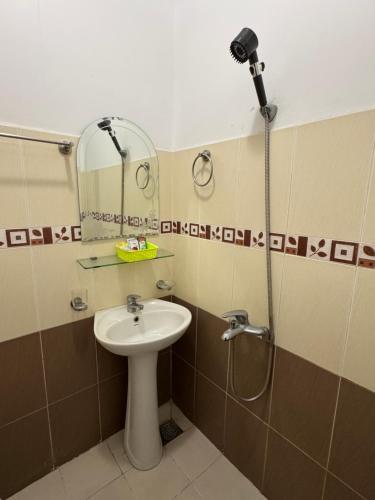 a bathroom with a sink and a shower with a mirror at Thinh Khang Hotel Vung Tau in Vung Tau