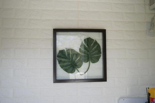 a framed picture of a plant on a wall at Dining Pension Ezura in Shirahama