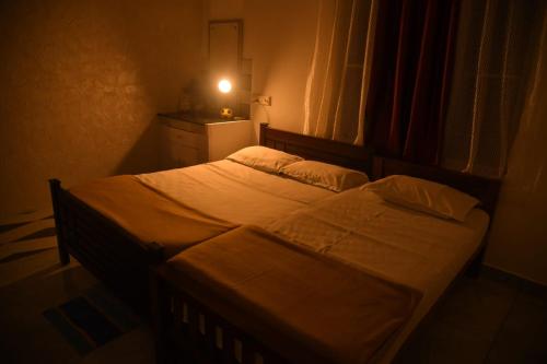 a bedroom with a large bed with a light on it at Olive Homestay in Cochin