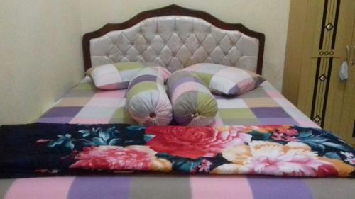 a bed with a pink and purple blanket and pillows at Villa Ardon Batu in Batu