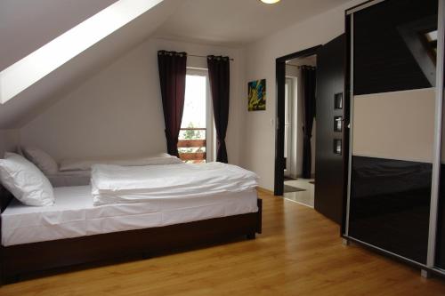 a bedroom with a white bed and a window at JD Apartamenty - Klimatyzacja, basen, parking i wifi w cenie in Mysłakowice