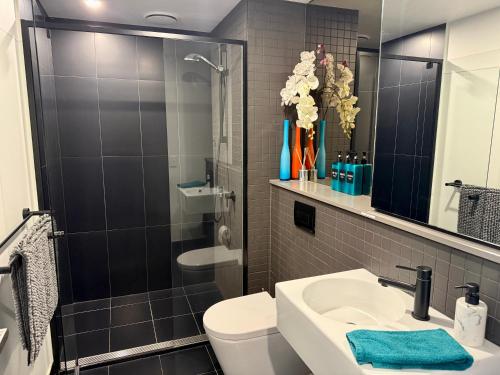 堪培拉Midnight Luxe 1BR 1Bath Apartment 104 in the heart of Braddon Pool Sauna Secure Parking Wine WiFi的带水槽、马桶和淋浴的浴室