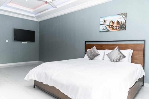 a bedroom with a large white bed with a flat screen tv at Yoyo Kunda in Bathurst