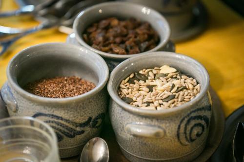 three bowls of nuts and seeds sitting on a table at Hotel Adonis in Zermatt