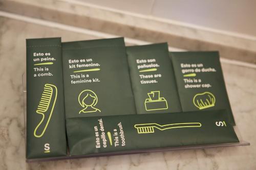 a shelf with three green boxes of hair products at Sercotel Hotel Parque in Las Palmas de Gran Canaria